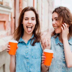 two girls being silly while grabbing coffee out