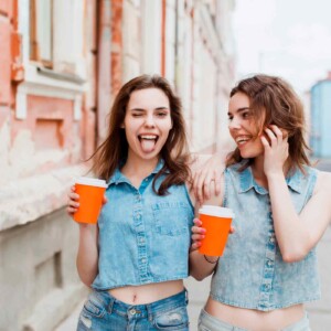 two girls being silly while grabbing coffee out